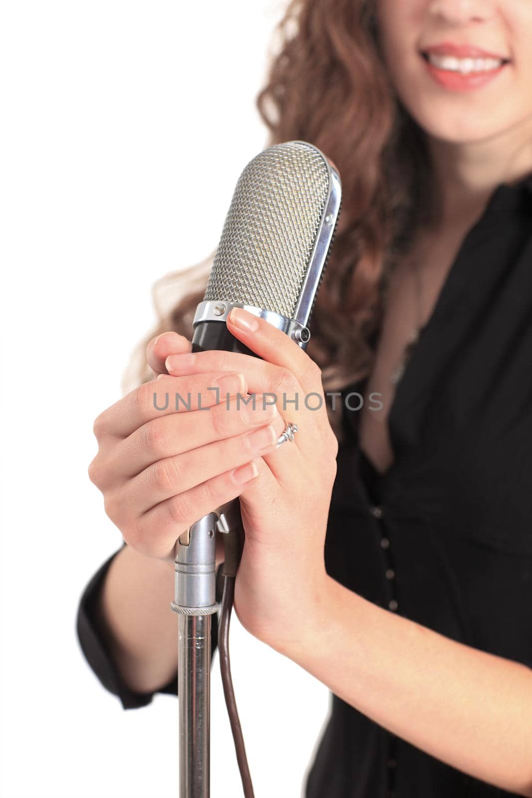 Closeup portrait of a pretty young female star performer holding old fashioned microphone .