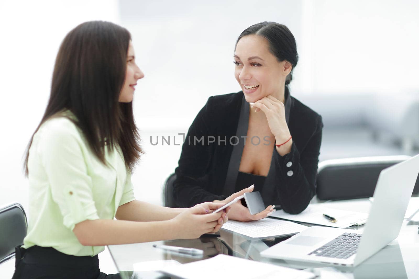 close up.two business women discussing working issues in the office by SmartPhotoLab