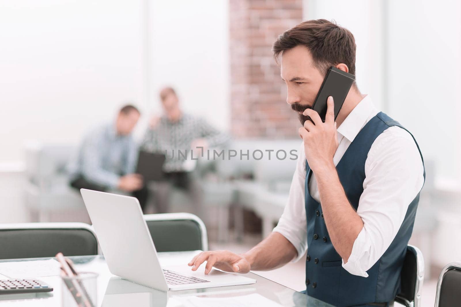 businessman talking on a smartphone sitting at his Desk.people and technology