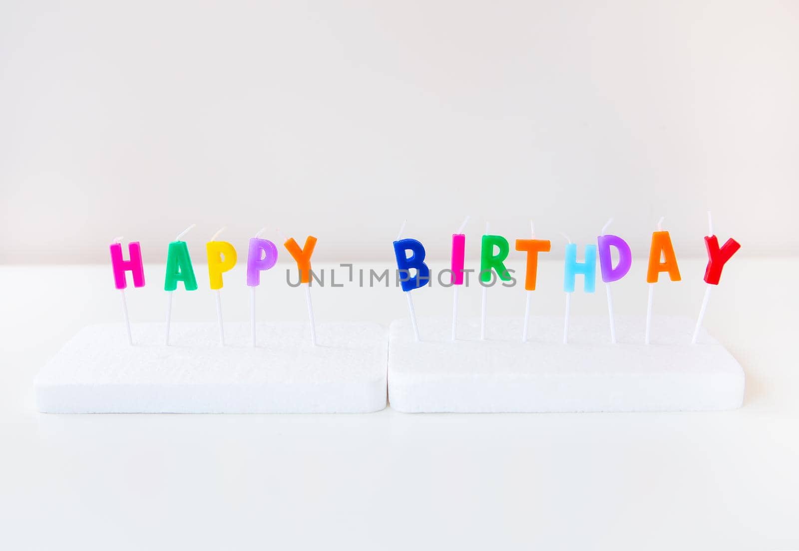 Colorful candles with the inscription Happy Birthday isolated on a white background. Holiday and surprise concept. by sfinks