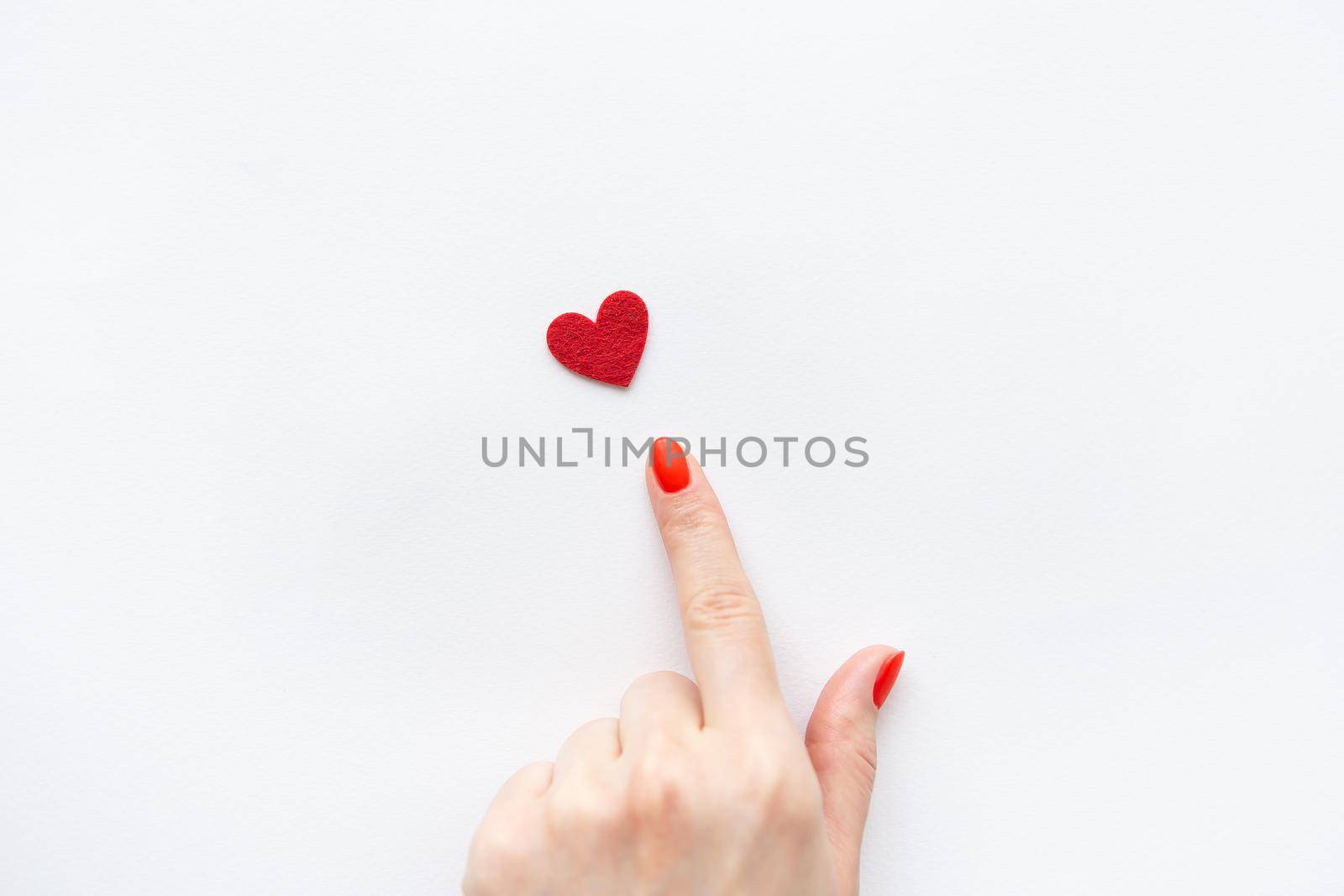 The girl's hand shows a small red heart. Place for an inscription. Health care and world health day concept