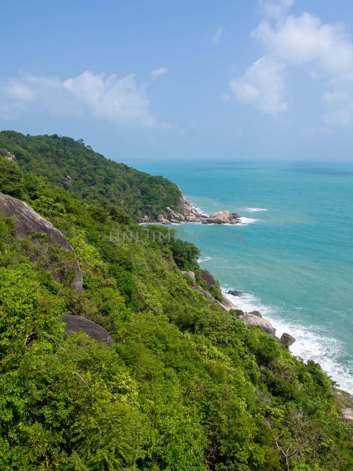 Rocky rock over beautiful clear sea and island, view from Kho Phangan, Thailand.