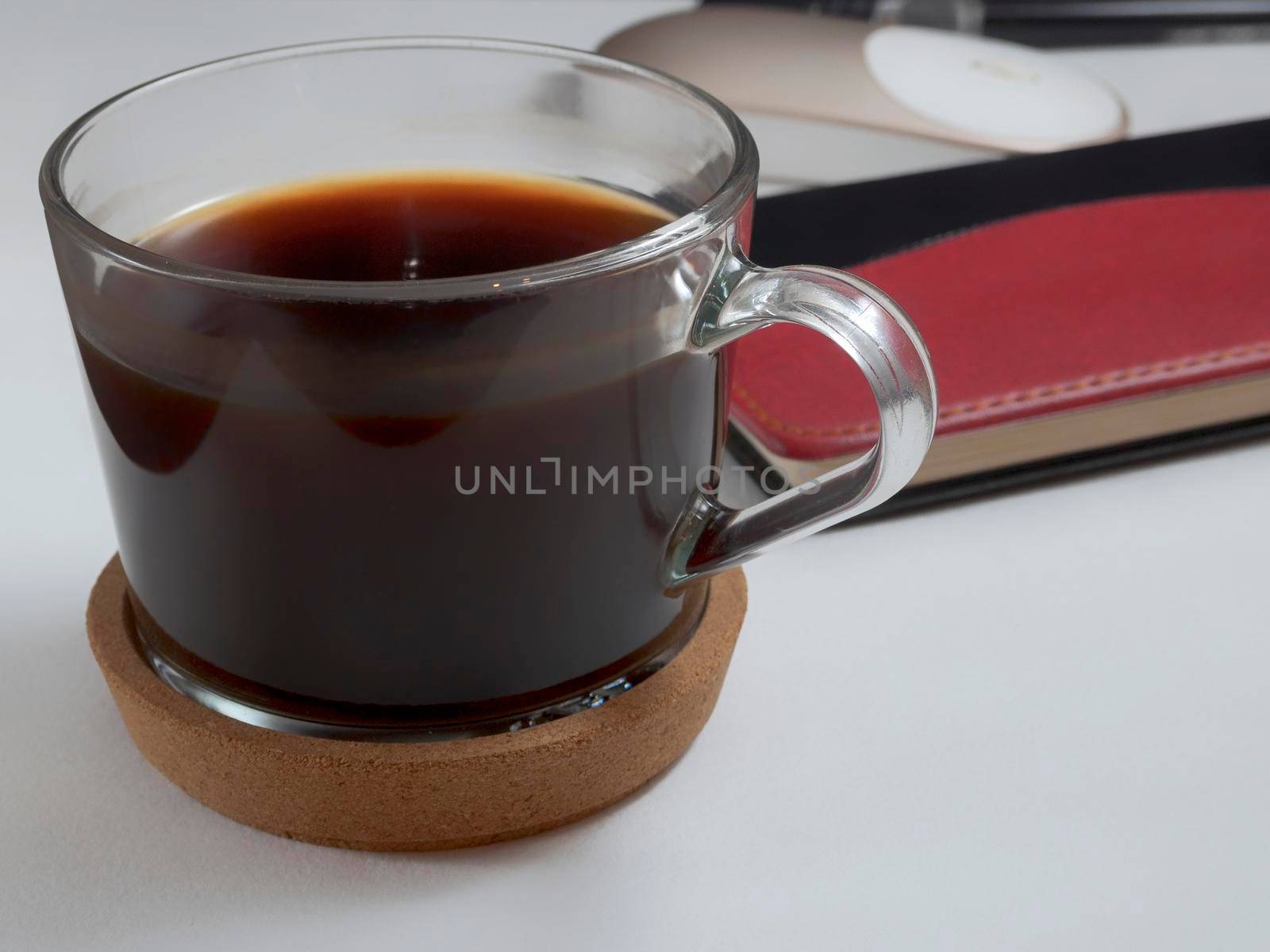 Workplace with notebook, pen and glass coffee mug on white background.