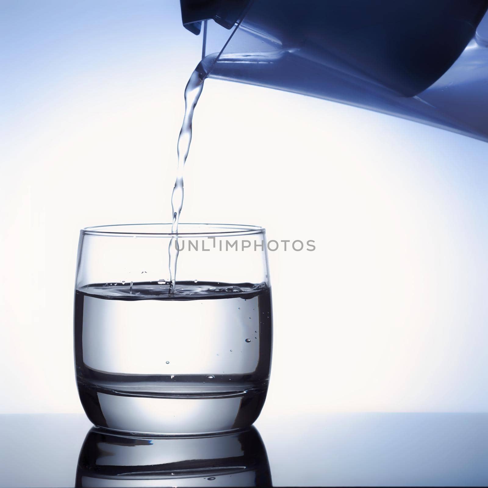 Pour water from a pitcher into a glass.