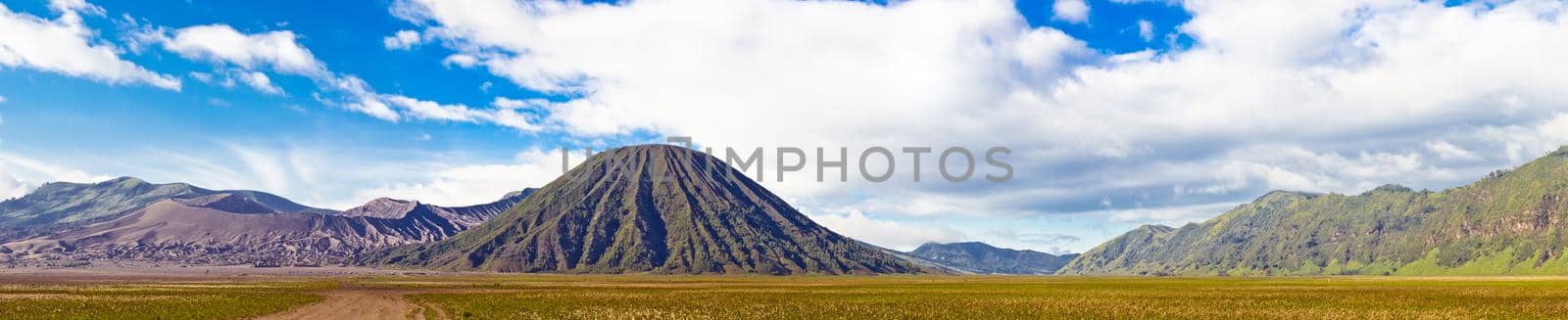 Panoramic view of volcanic landscape against blue sky with cloud by dmitryz