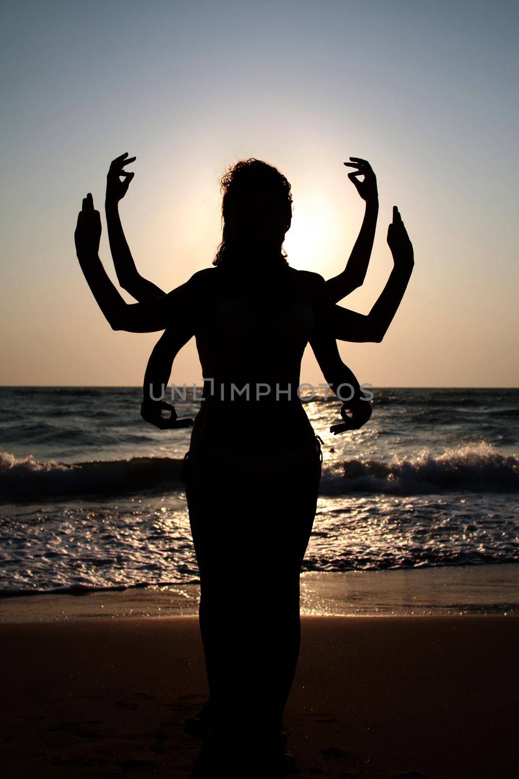 Girls silhouettes standing at the beach with arms raised up. Yog by dmitryz