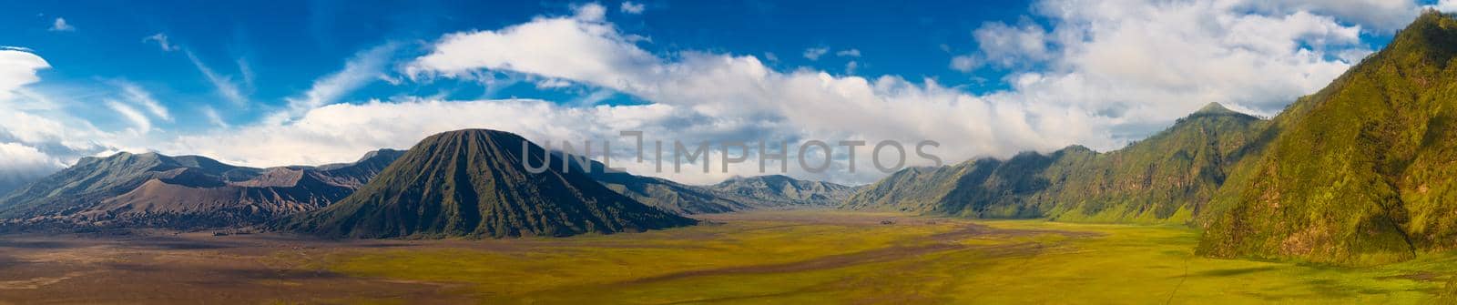 Panoramic view of volcanic landscape against blue sky with clouds. Bromo Tengger Semeru National Park, East Java, Indonesia