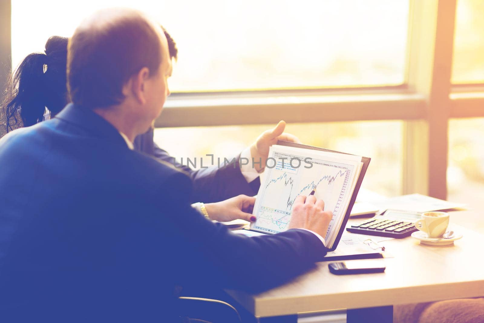 Close-up of female and male hands pointing at business document while discussing it