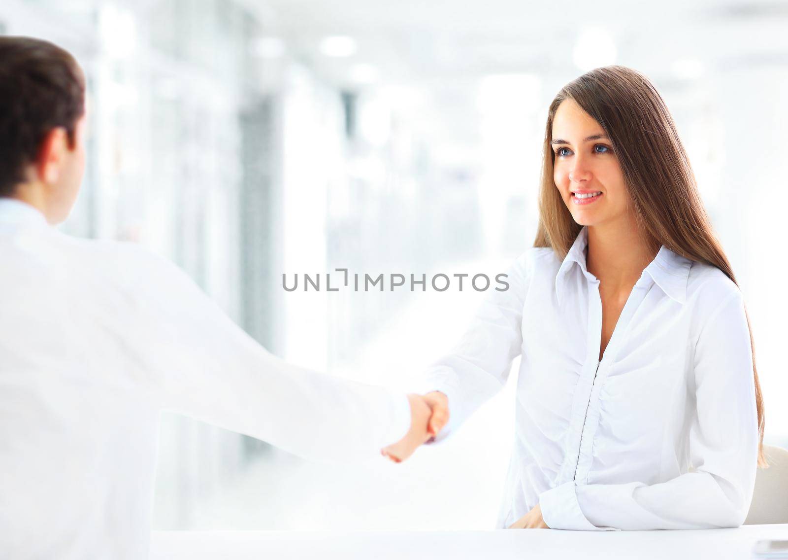 Cheerful businesspeople, or businesswoman and client handshaking by SmartPhotoLab