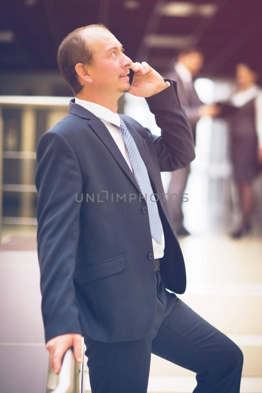 business man talking on cell phone at modern office by SmartPhotoLab