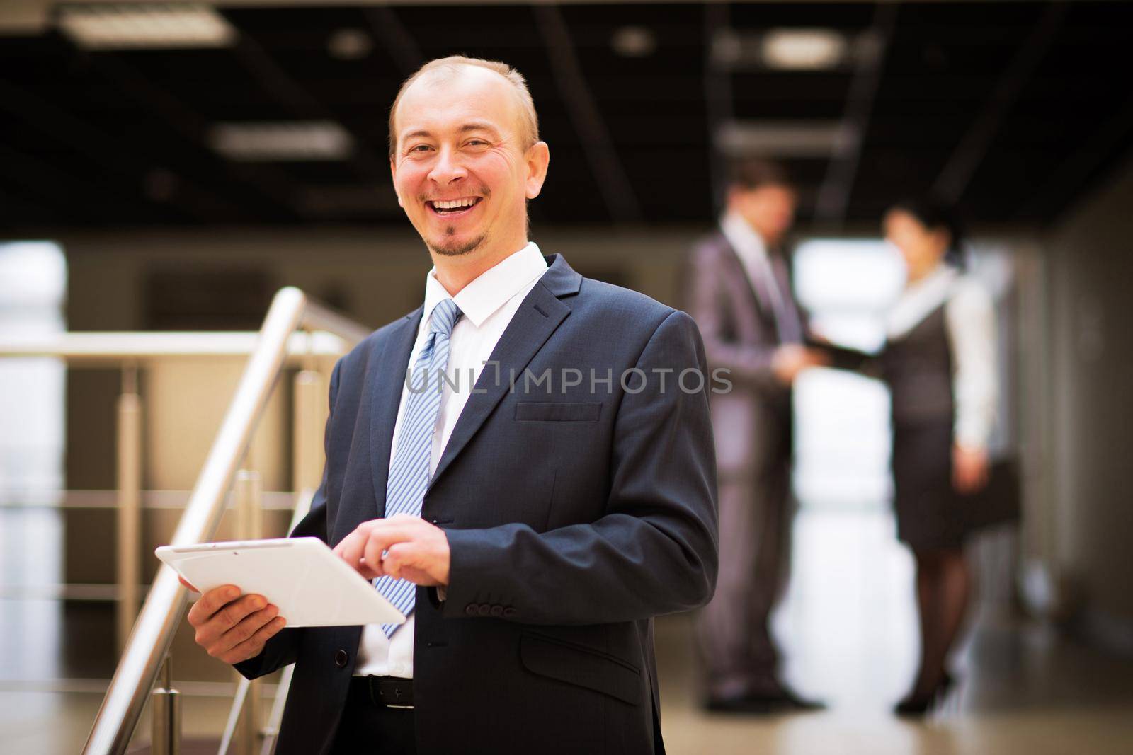 Happy mature business man looking at camera with satisfaction at office