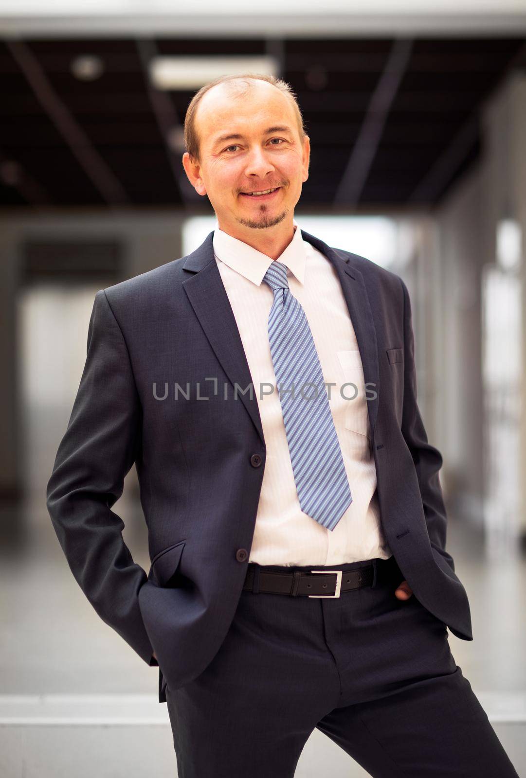 Happy mature business man looking at camera with satisfaction at office