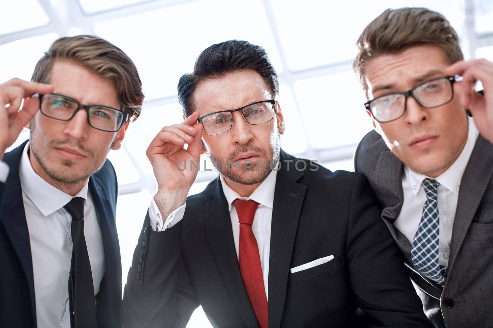 close up.three attentive businessmen looking at the camera by asdf