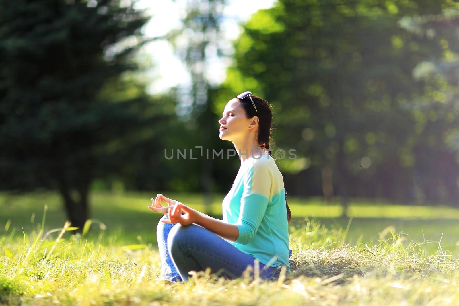 Attractive young woman in a lotus position by SmartPhotoLab