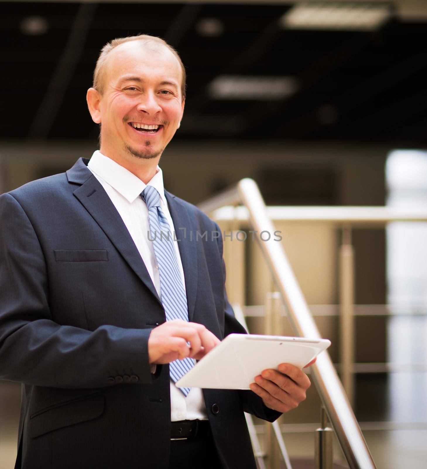 Happy mature business man looking at camera with satisfaction at office