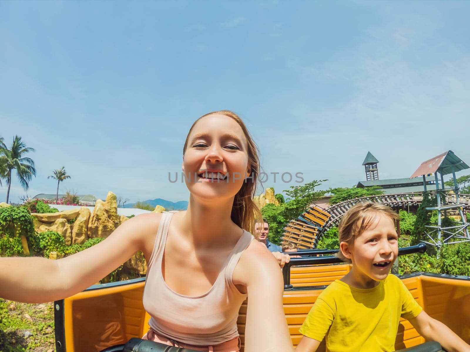 Mother and son having fun on rollercoaster by galitskaya