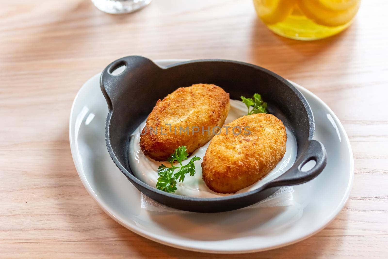 Hashbrown, hash brown potatoes fried pancakes, traditional american cuisine. Crispy hashed browned potatoes in blue plate on dark brown table, top view.