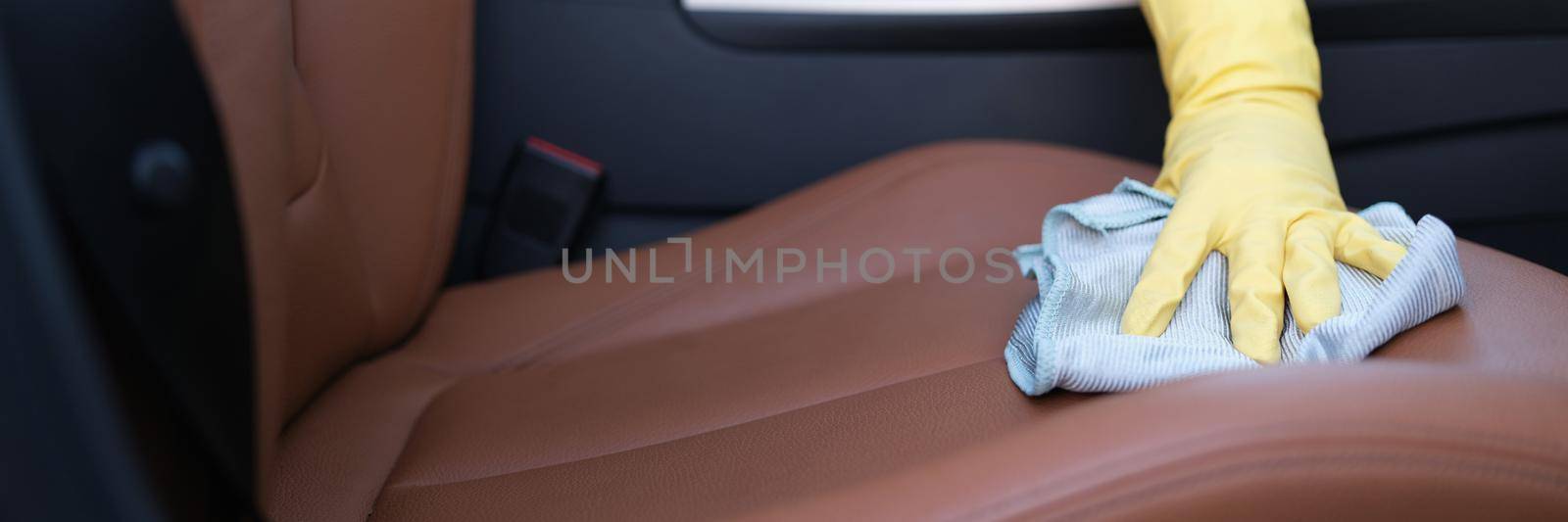 Close-up of male hands in protective gloves cleaning car interior with special disinfectant. Coronavirus disinfection during covid-19 pandemic concept