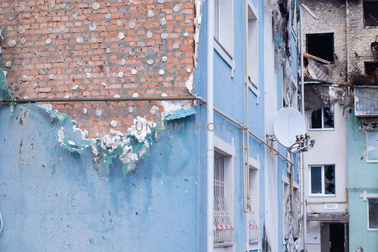 consequences of russian war crimes. destroyed houses in irpin city, ukraine. mortar shell hit someone home during war.