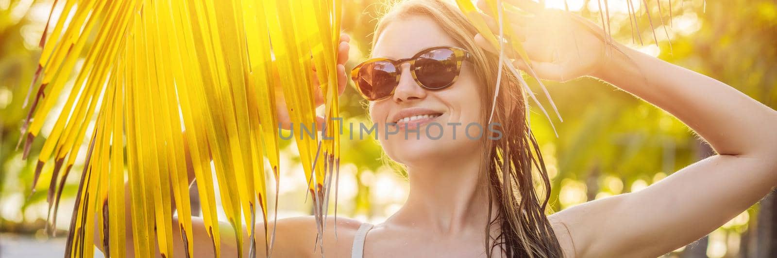 young beautiful woman in swimsuit on tropical beach, summer vacation, palm tree leaf, tanned skin, sand, smiling, happy. Happy traveller woman BANNER, LONG FORMAT by galitskaya