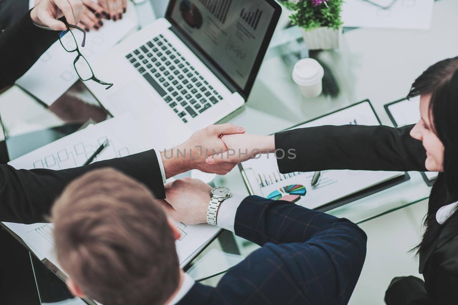 handshake business partners in the workplace in a modern office.