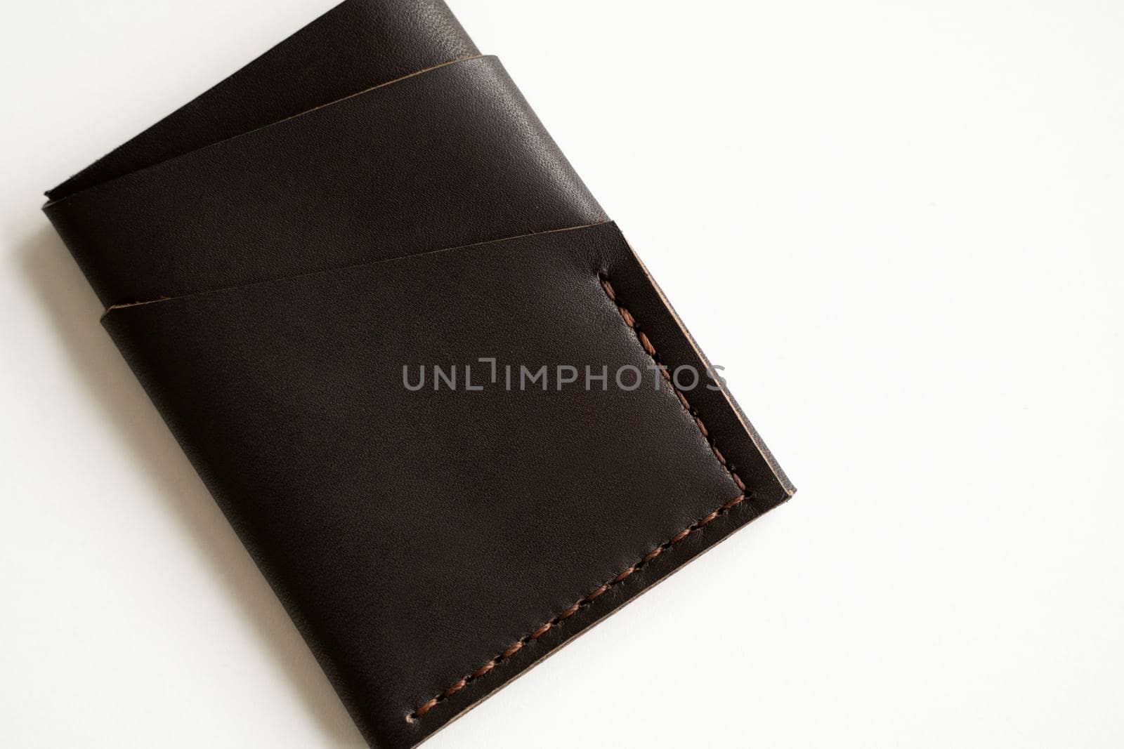 Brown empty men's business handmade leather card holder with isolated on white background. Selective focus, copy space, close up. by vovsht