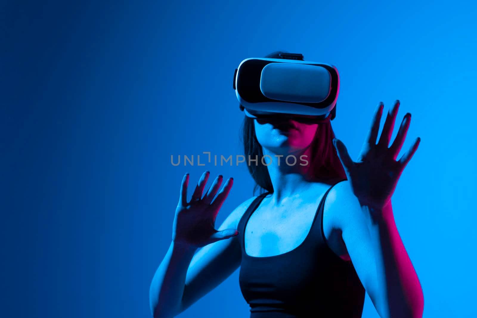 Woman in VR headset looking up at the objects in virtual reality while playing a game or watching 3d movie. Future technology concept. by vovsht