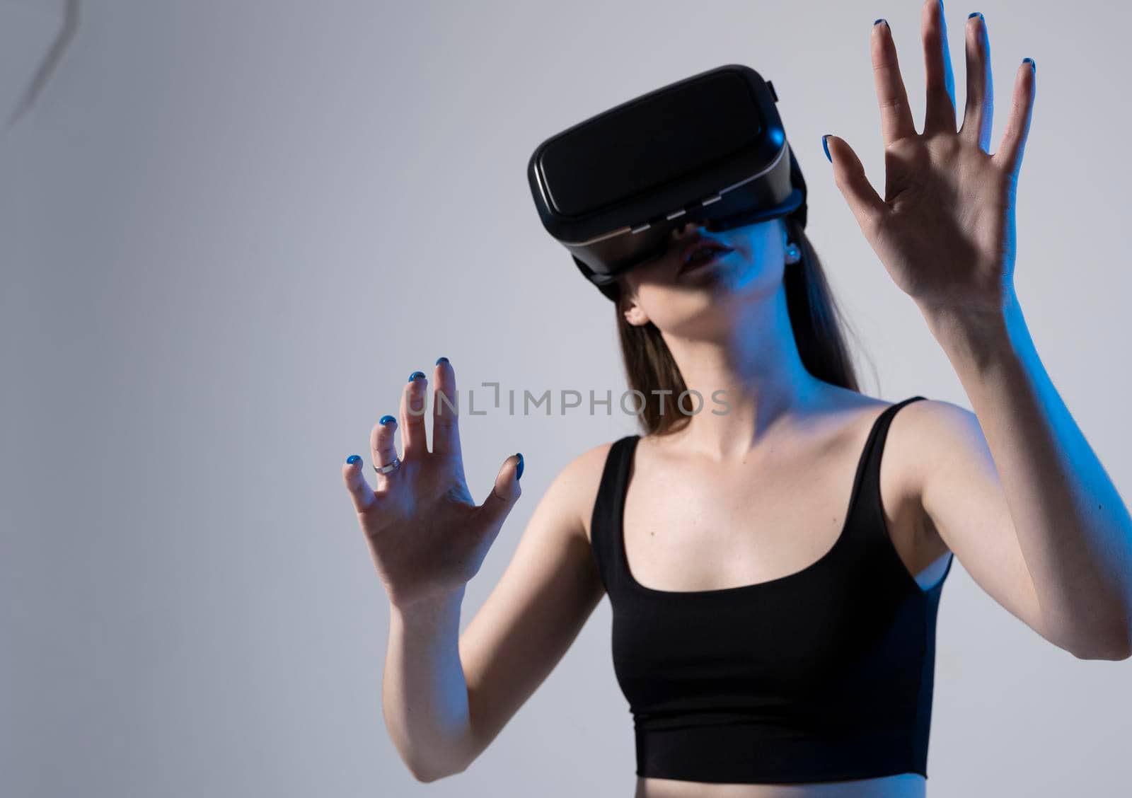 Young attractive brunette woman wearing VR goggles and enjoying amazing experience playing and having fun in virtual reality video game. by vovsht