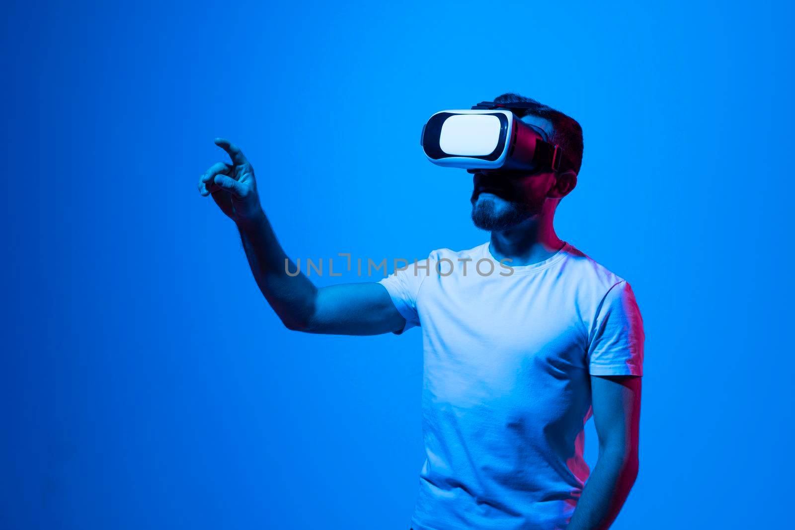 Modern architect, designer using virtual reality glasses at workplace. Designer working in augmented reality vr studio. Man working in VR goggles on a studio background