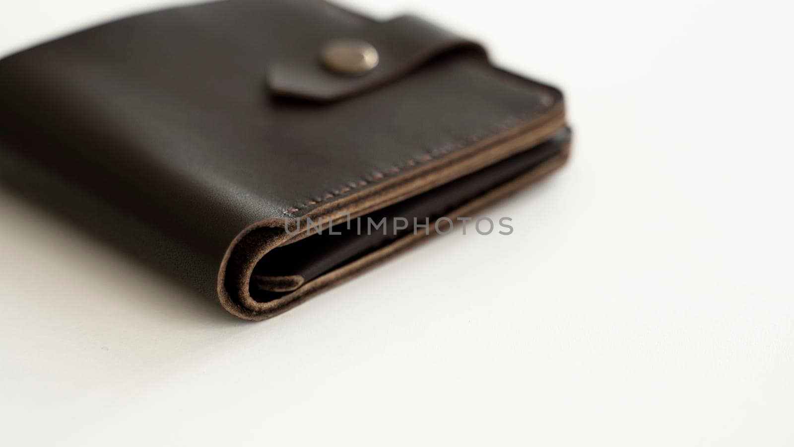 Top view of brown empty man's black handmade genuine leather wallet for banknotes and credit cards isolated on white background. Selective focus, copy space, Close up. by vovsht