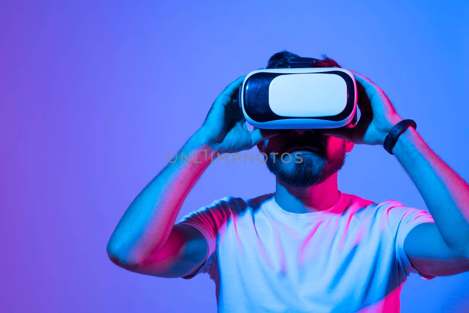 Closeup of young man developer wearing virtual reality goggles in modern studio workspace and working on a new perspective project