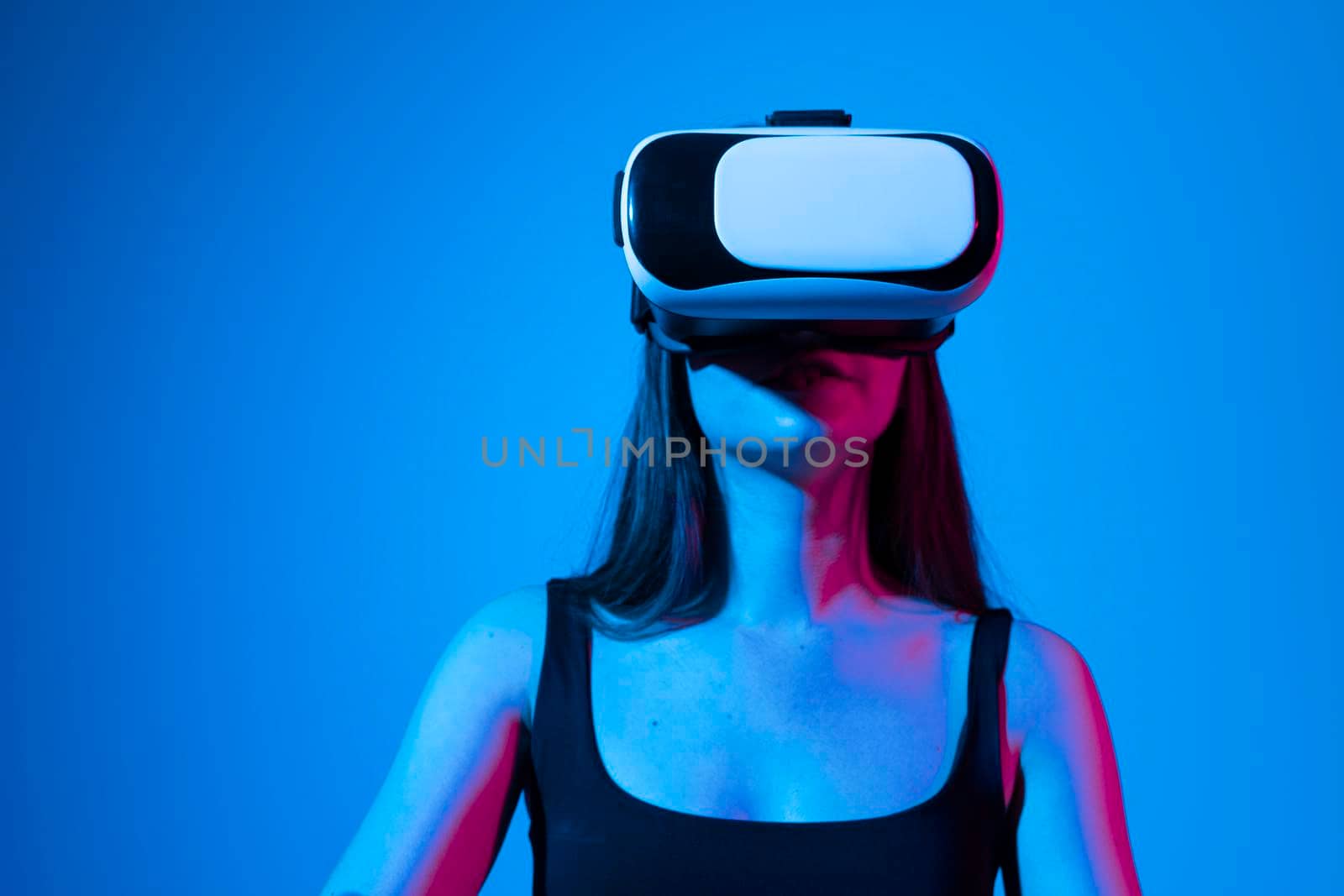 Amazed female in VR glasses headset interacting with network while having virtual reality experience. Future technology concept. Metaverse. by vovsht