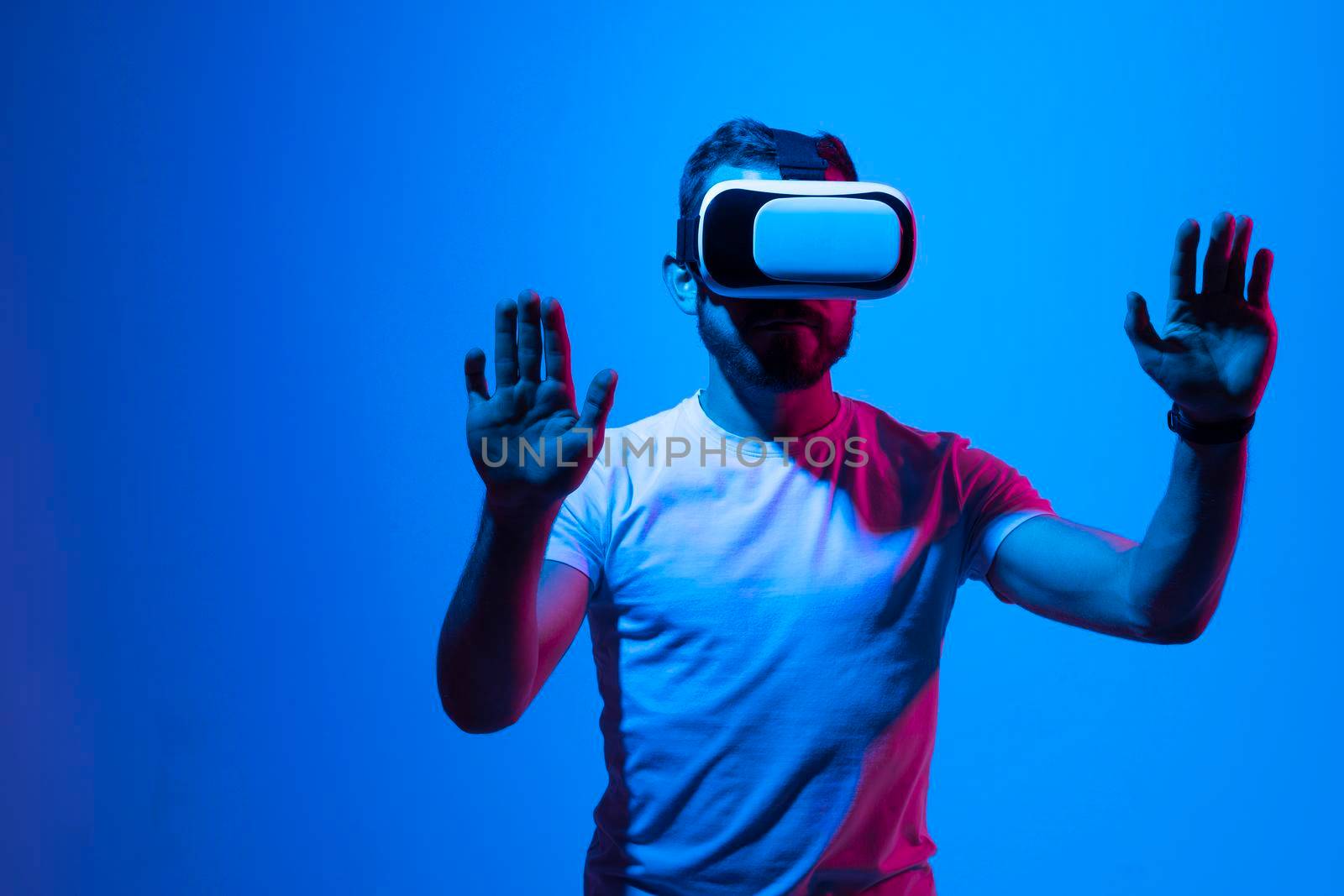 Modern architect, designer using virtual reality glasses at workplace. Designer working in augmented reality vr studio. Man working in VR goggles on a studio background