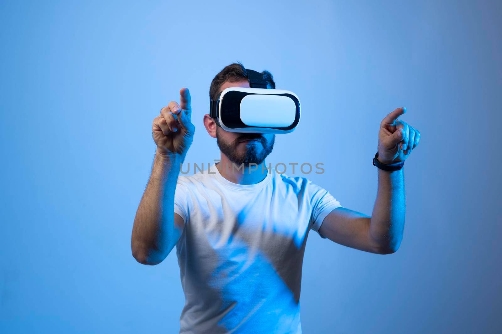 Modern architect, designer using virtual reality glasses at workplace. Designer working in augmented reality vr studio. Man working in VR goggles on a studio background. by vovsht