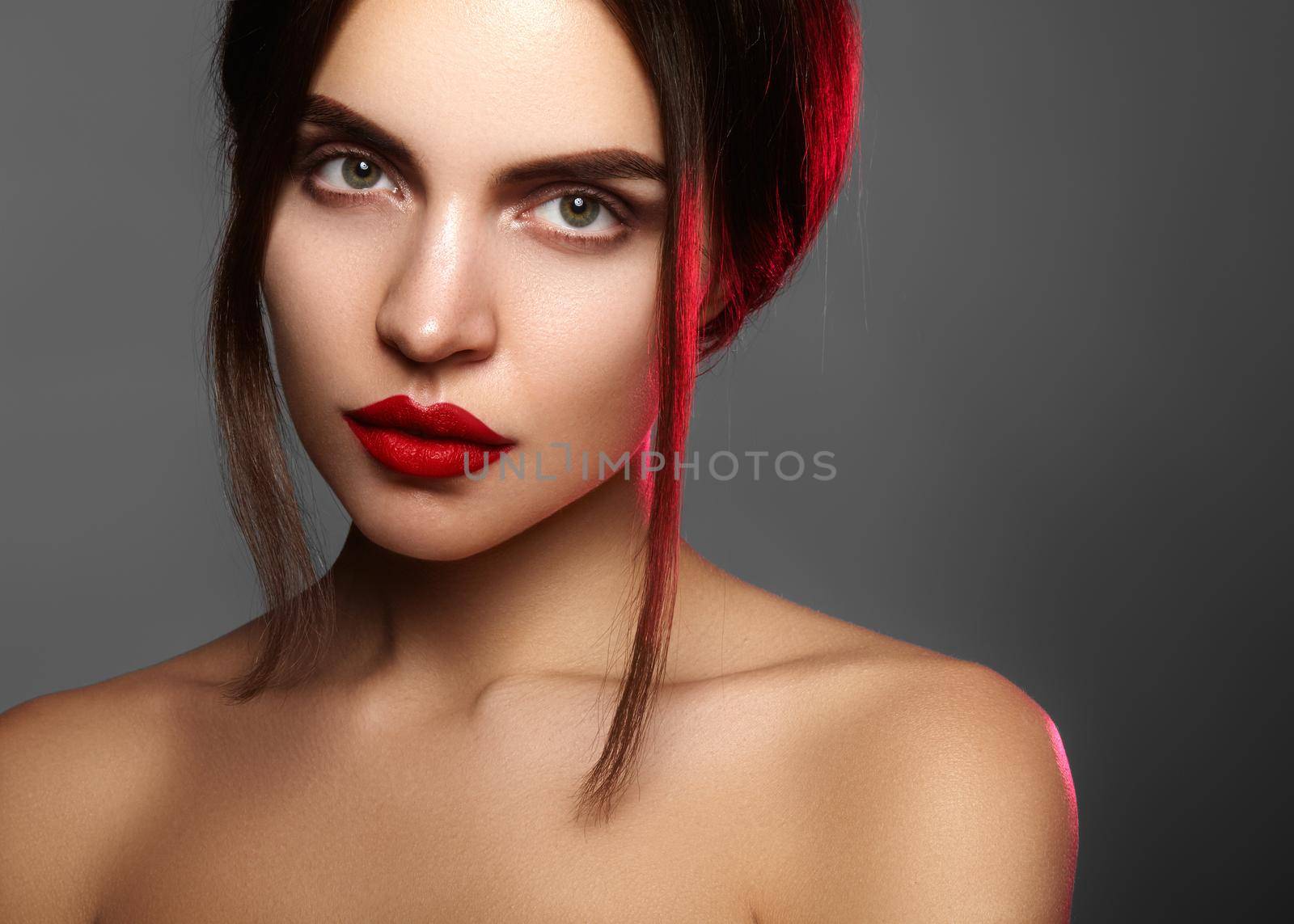 Beautiful model with fashion make-up. Close-up portrait sexy woman with glamour lip gloss makeup and bright eye shadows. Macro shot of celebrate visage, clean skin, lips with red lipstick, eyeshadows.