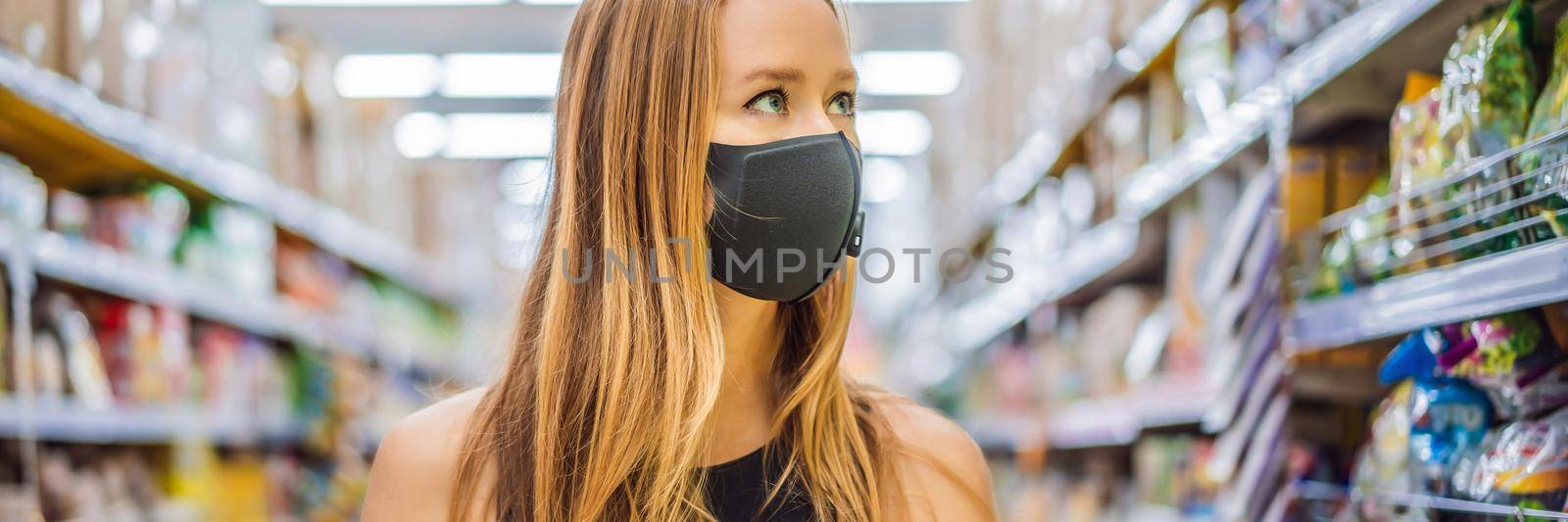 Alarmed female wears medical mask against coronavirus while grocery shopping in supermarket or store- health, safety and pandemic concept - young woman wearing protective mask and stockpiling food BANNER, LONG FORMAT by galitskaya