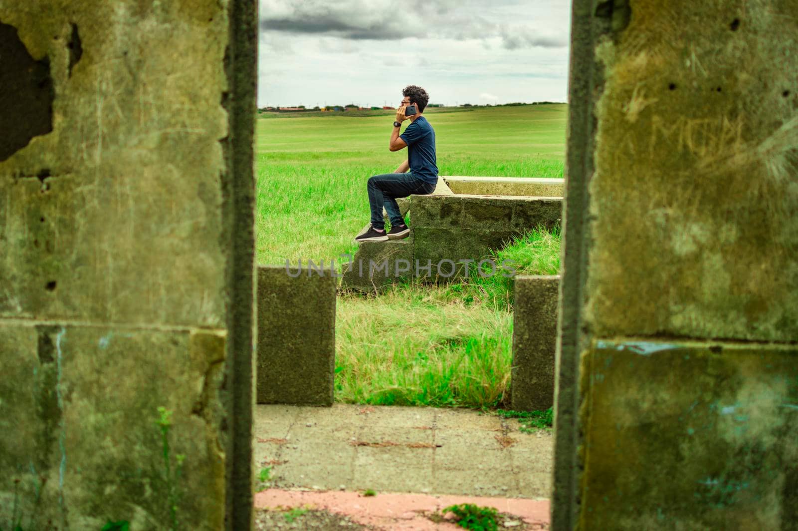Man calling by cell phone, young man in the field calling by cell phone