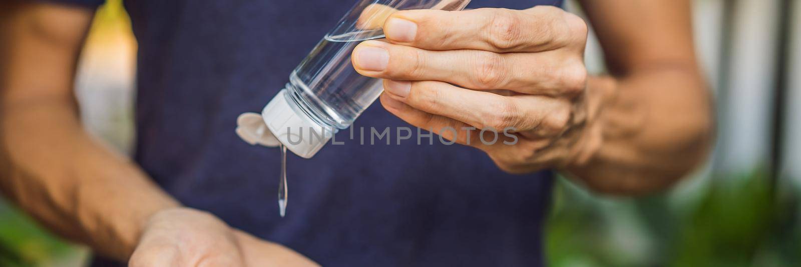 Men's hands using wash hand sanitizer gel. BANNER, LONG FORMAT