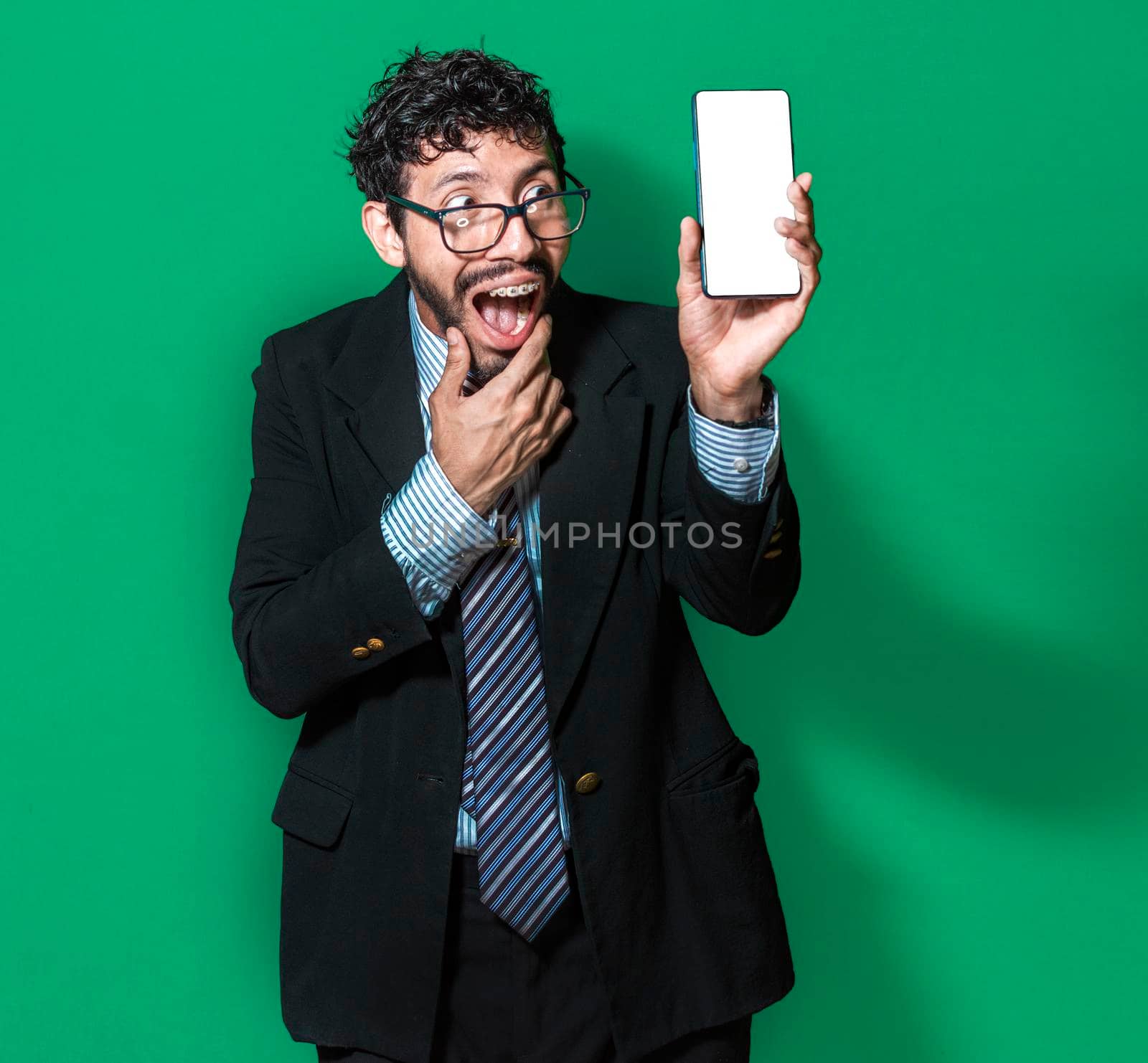 Businessman showing a cell phone from the front, happy businessman showing his cell phone isolated