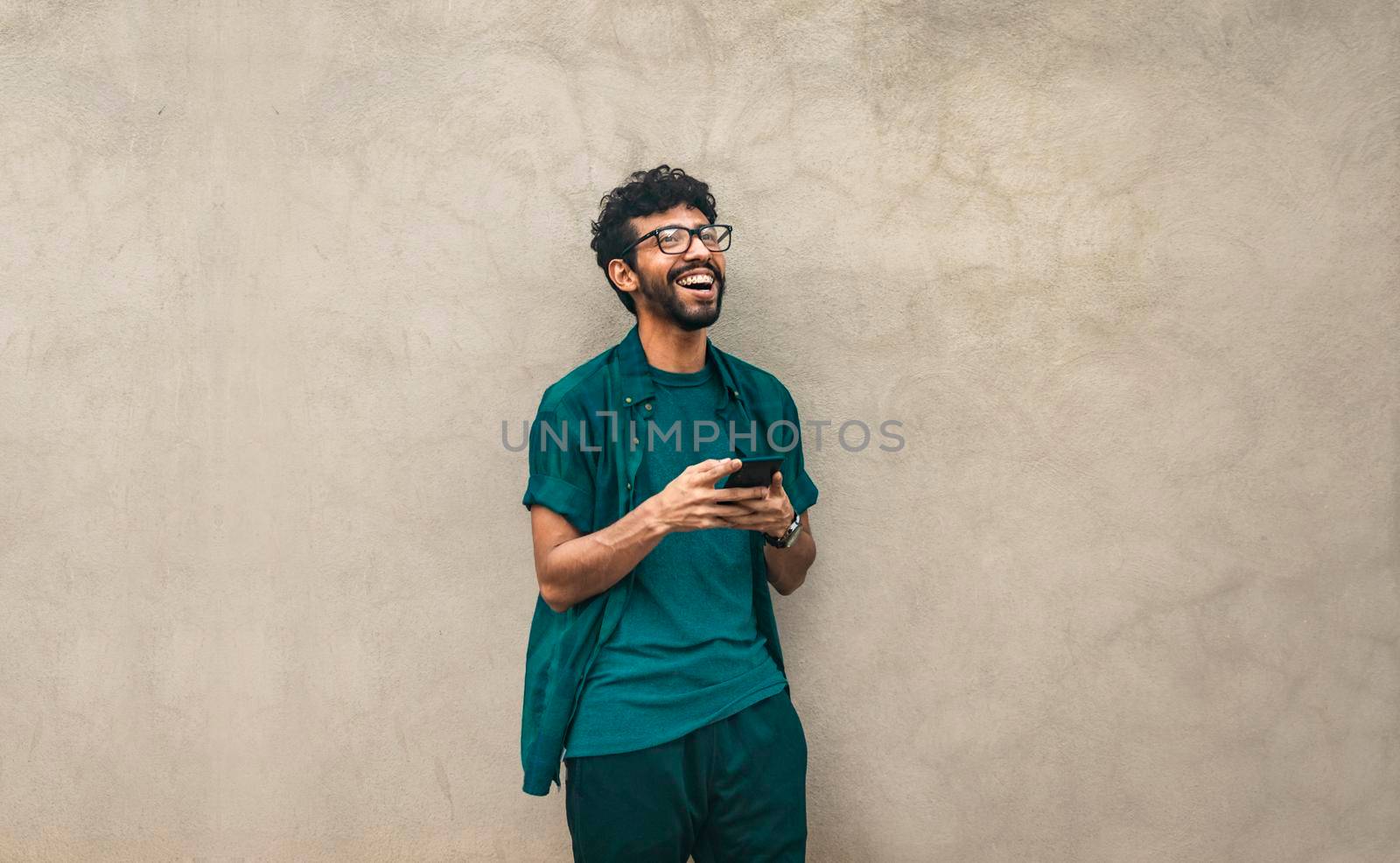 Handsome guy happy with his cell phone, young latin man happy with his cell phone