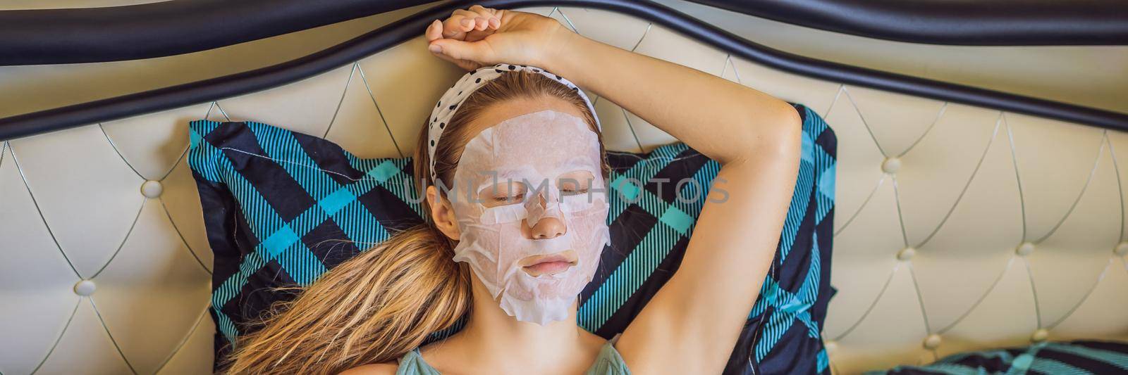 Young red-haired woman doing facial mask sheet. Beauty and Skin Care Concept. BANNER, LONG FORMAT