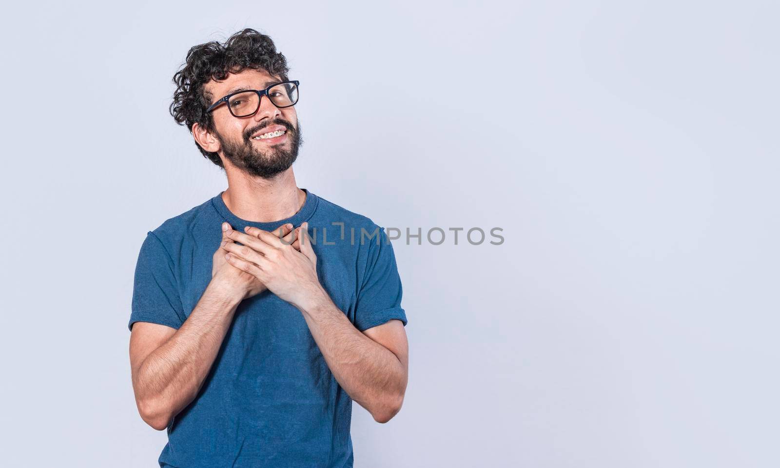Attractive friendly and positive looking young man with a charming sincere smile feeling grateful