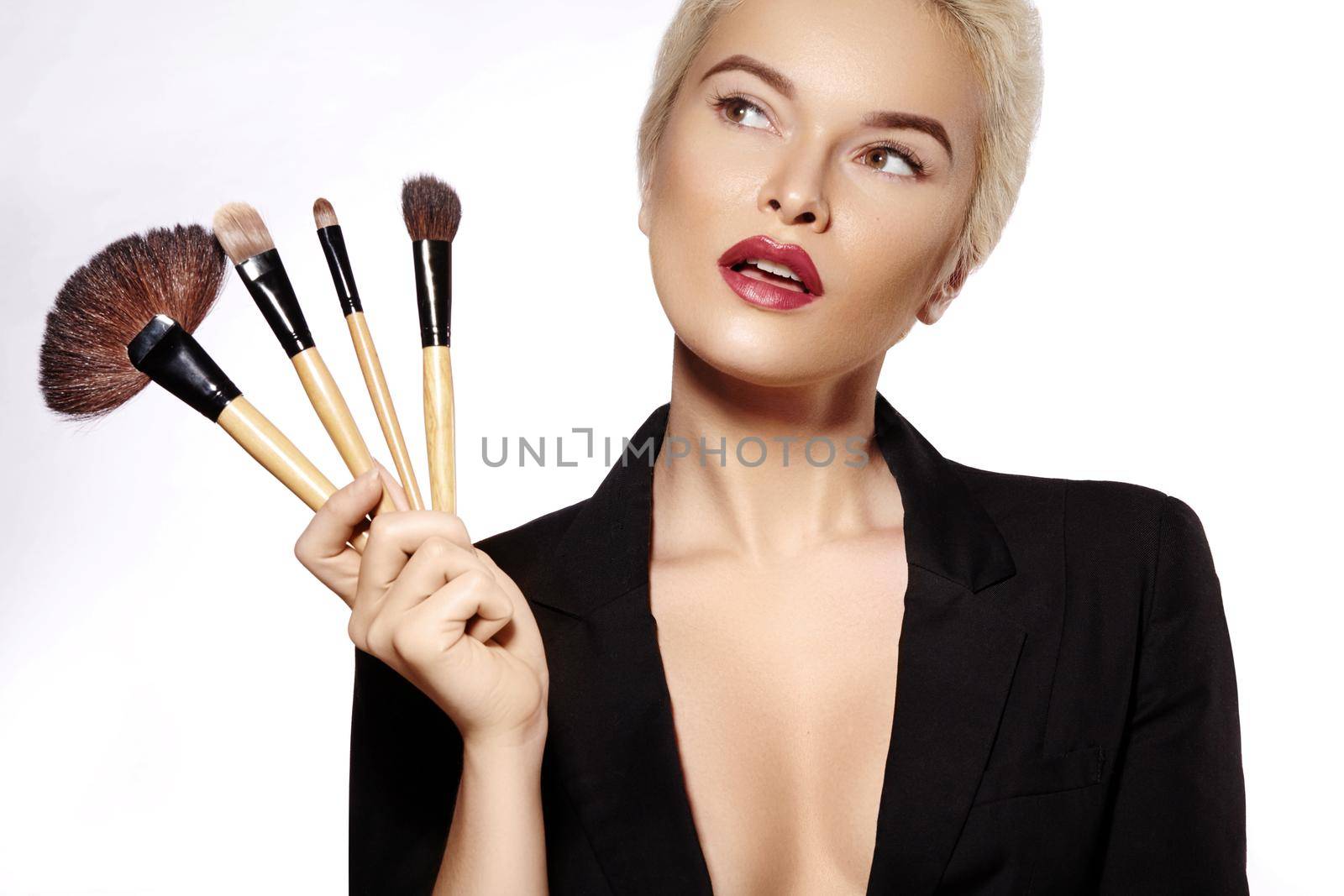 Beauty Treatment. Girl with Makeup Brushes. Fashion Make-up for Sexy Woman. Makeover. Make-up Artist Applying Visage on white background