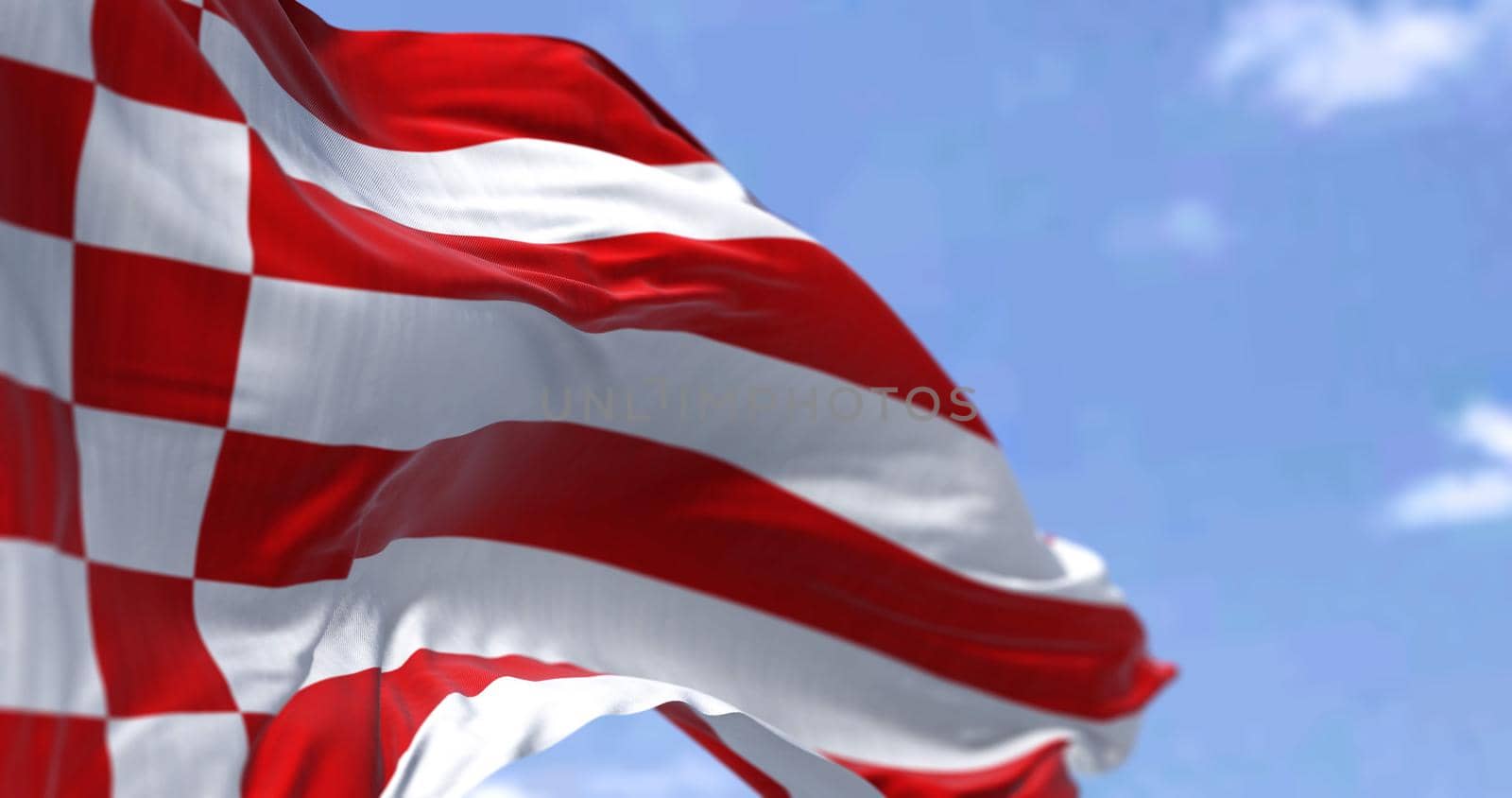 The civil flag of Bremen waving in the wind on a clear day. Bremen is the capital of the German state Free Hanseatic City of Bremen