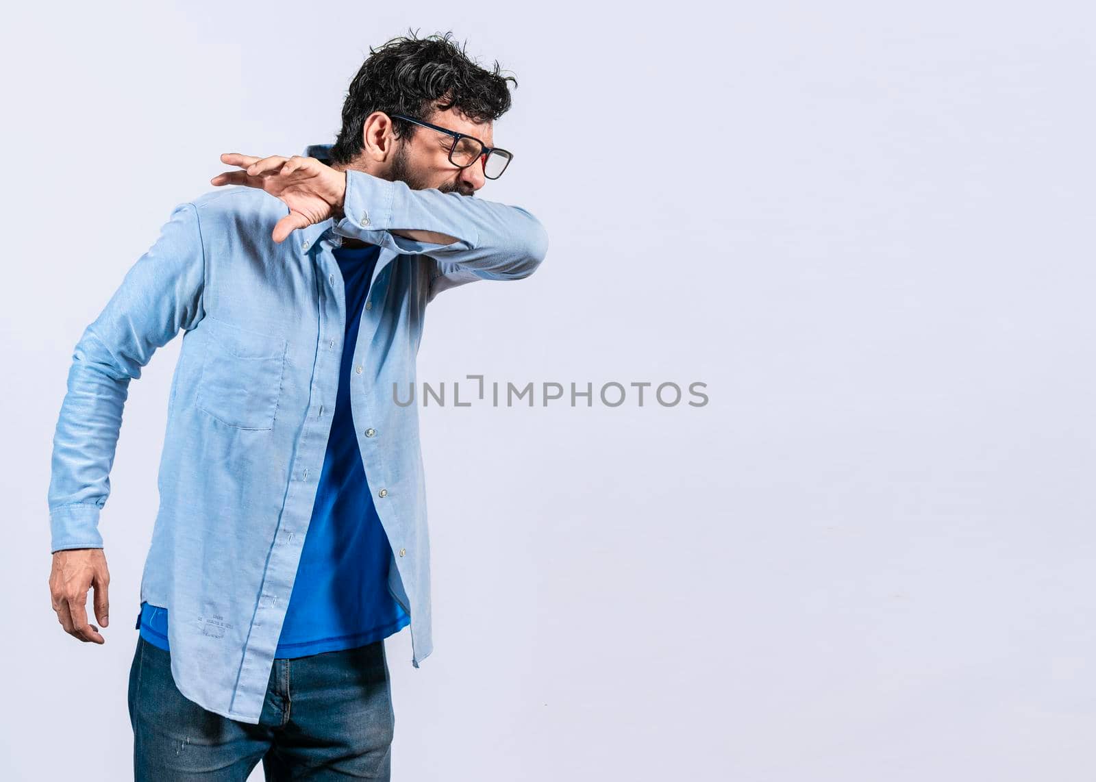 Beard man sneezing with his elbow, A guy sneezing with his elbow on isolated background, concept of man having a cold sneezing with his elbow