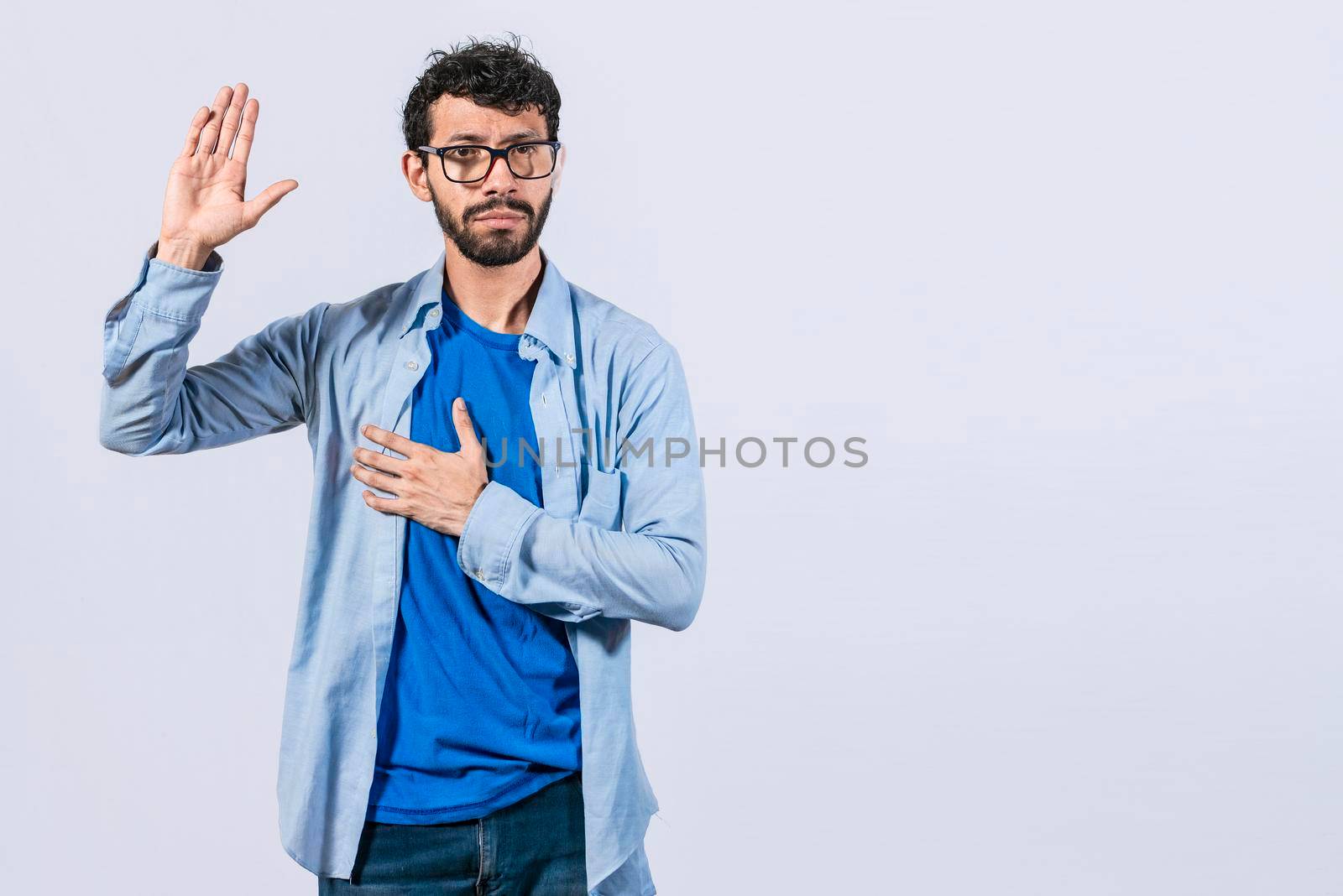 Man swearing honesty and devotion, Honest man raising his hand, a A guy raising his hand swearing, young man raising a hand promising something