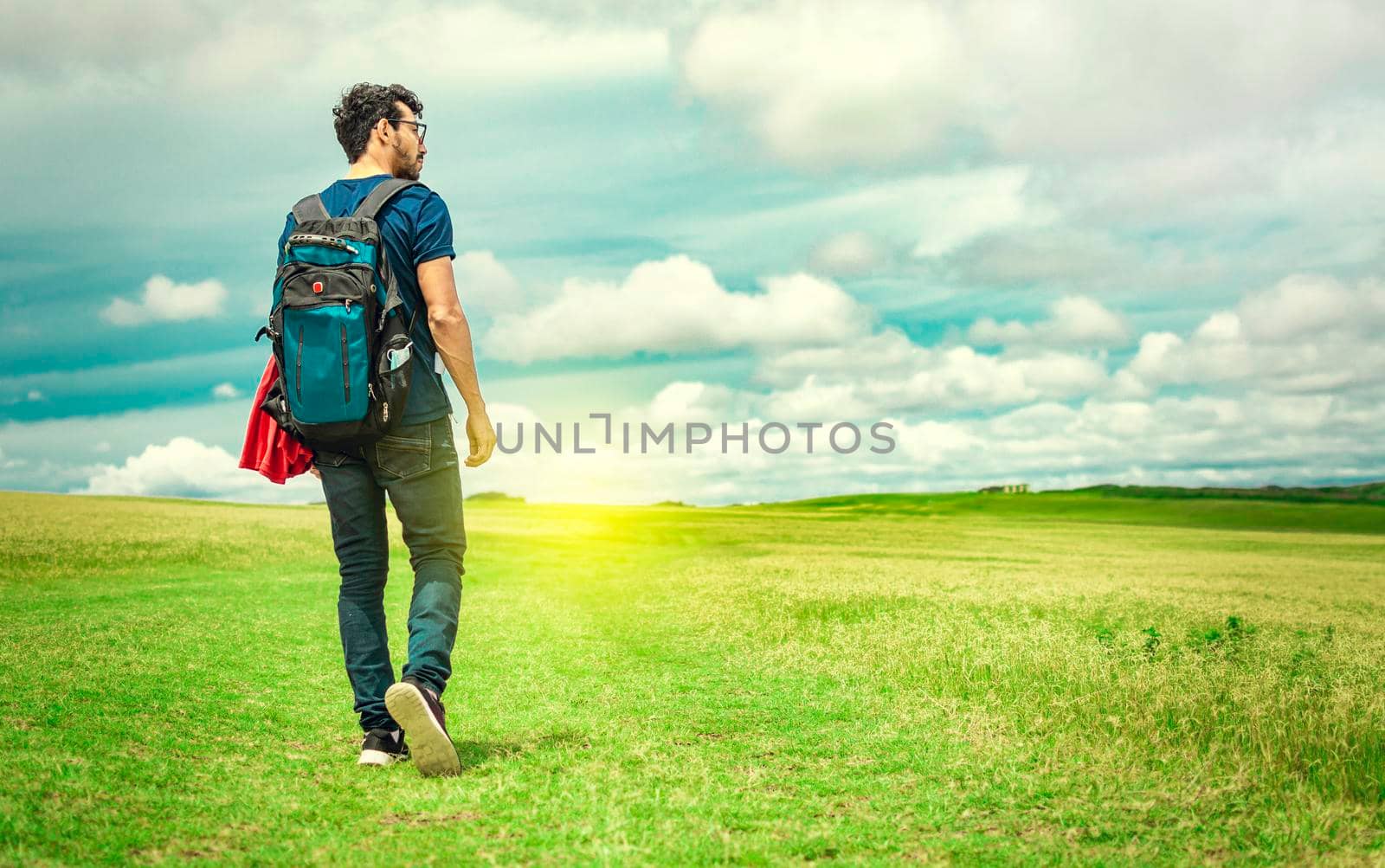 Adventurous man in the field, man with backpack in the field looking