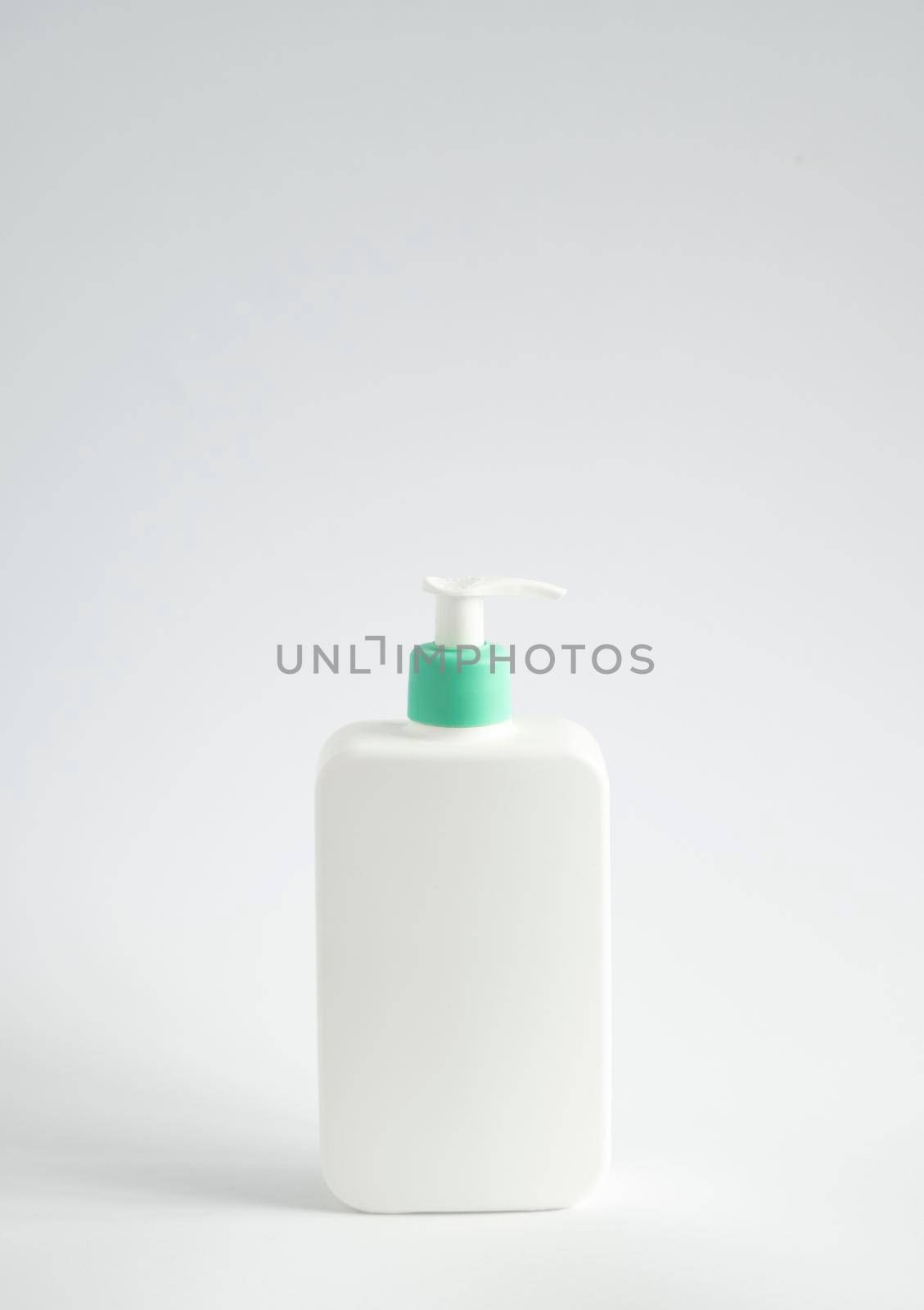 Liquid container for gel, lotion, cream, shampoo, bath foam. Cosmetic plastic bottle with green dispenser pump on white background. Cosmetic packaging mockup with copy space