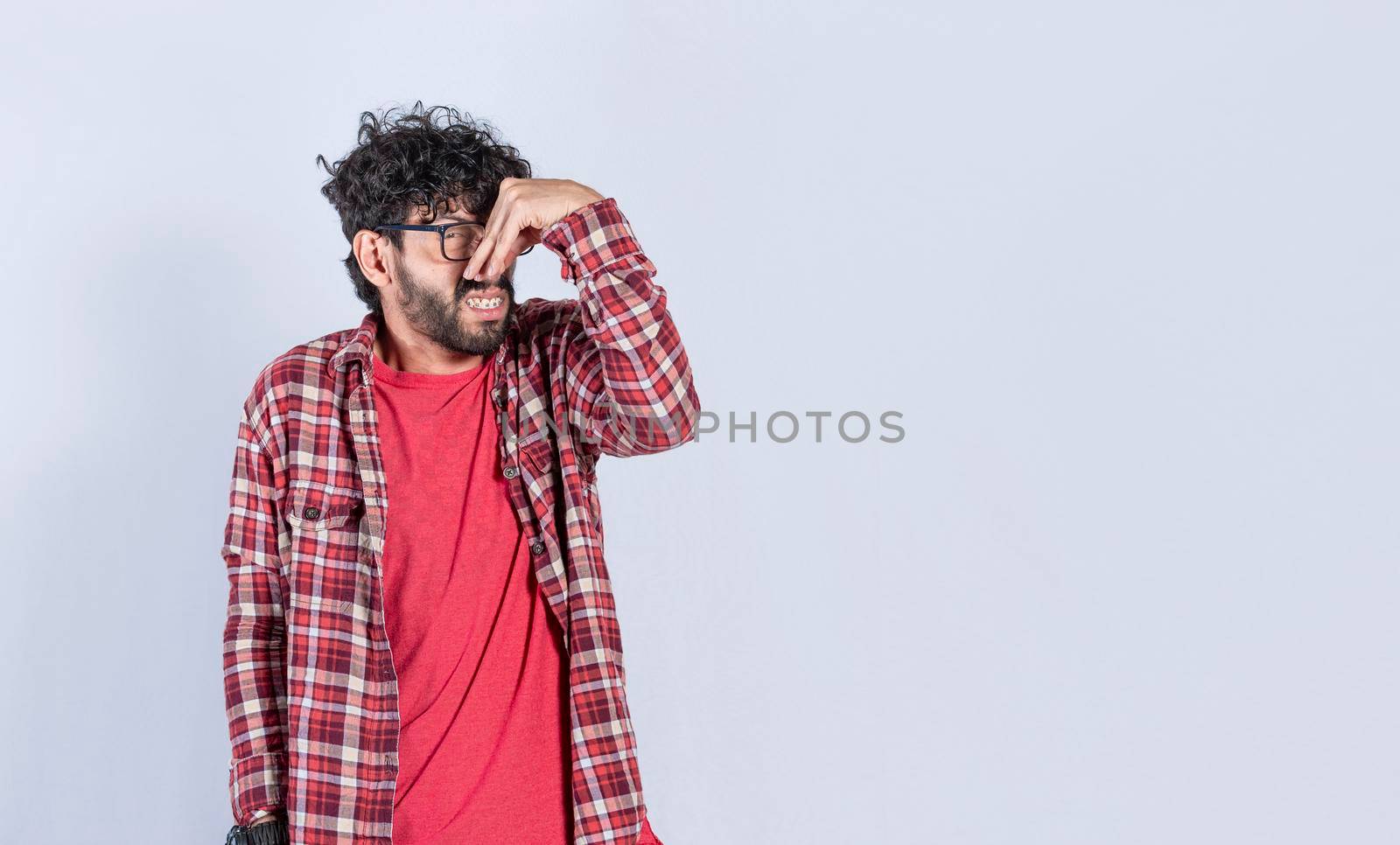 A man with covering his nose, a guy with a face of unpleasant odors, concept of bad smells