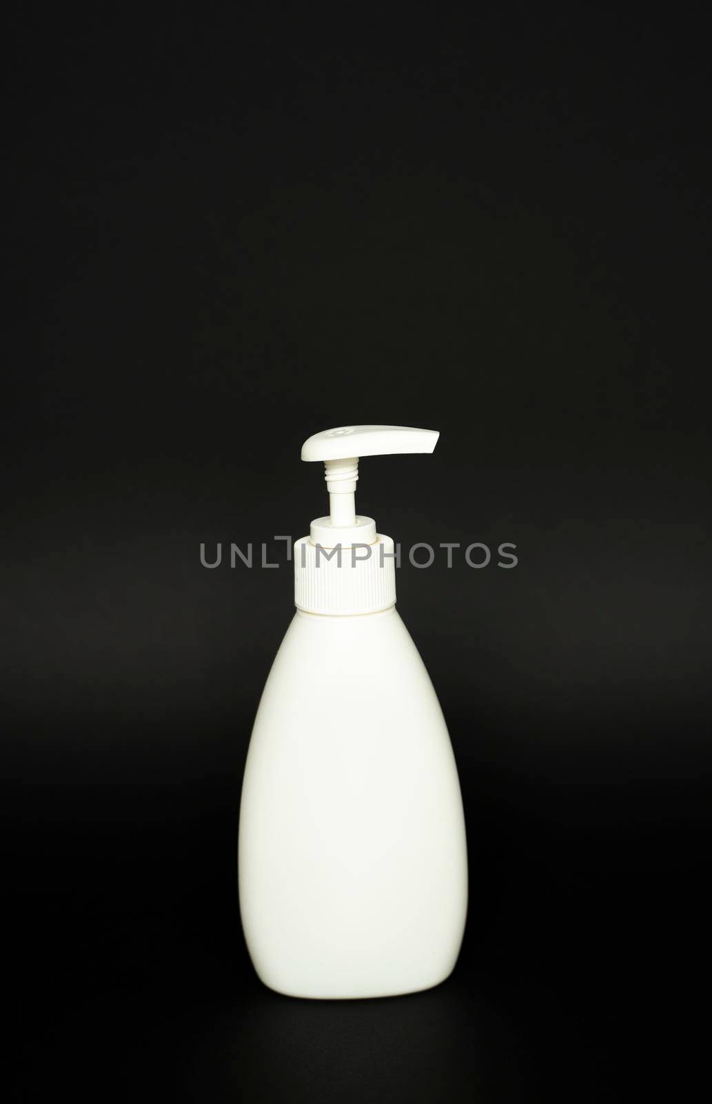 White plastic bottle used for shampoo or soap on black background.. Mock up template for design. by vovsht